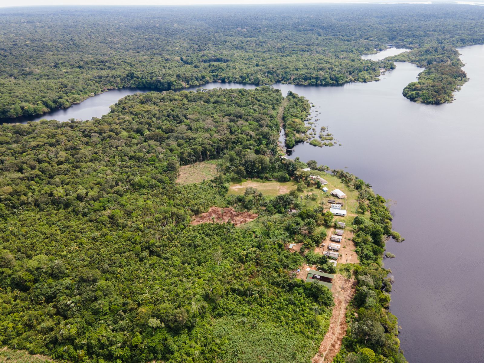 Vista aérea do Rio Negro e da floresta, com a área do lodge às margens do rio