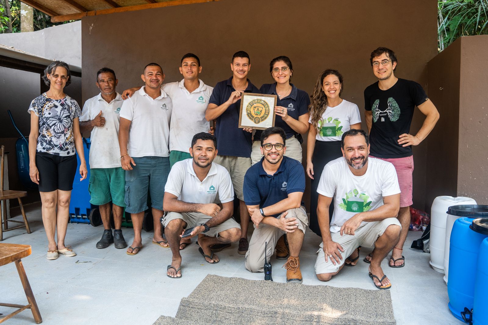 Equipe do lodge e da Yby posa com um certificado no espaço de compostagem