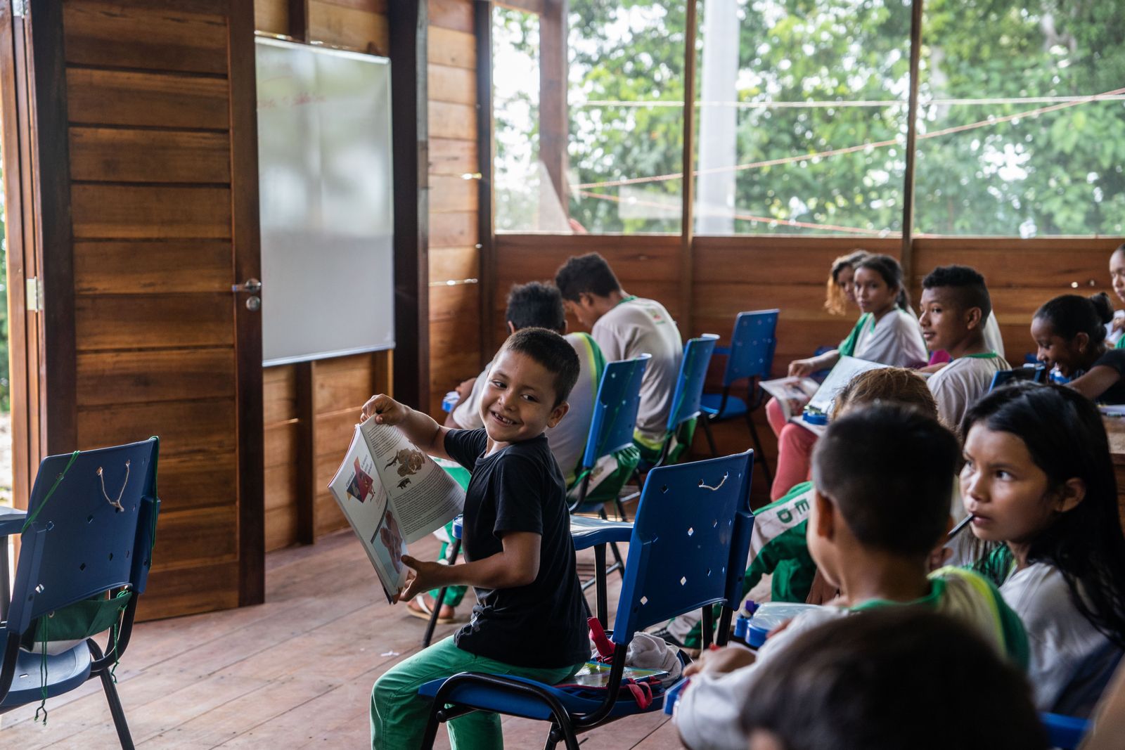 Mãos de alunos e professora apontam um mapa da região durante uma atividade na escola
