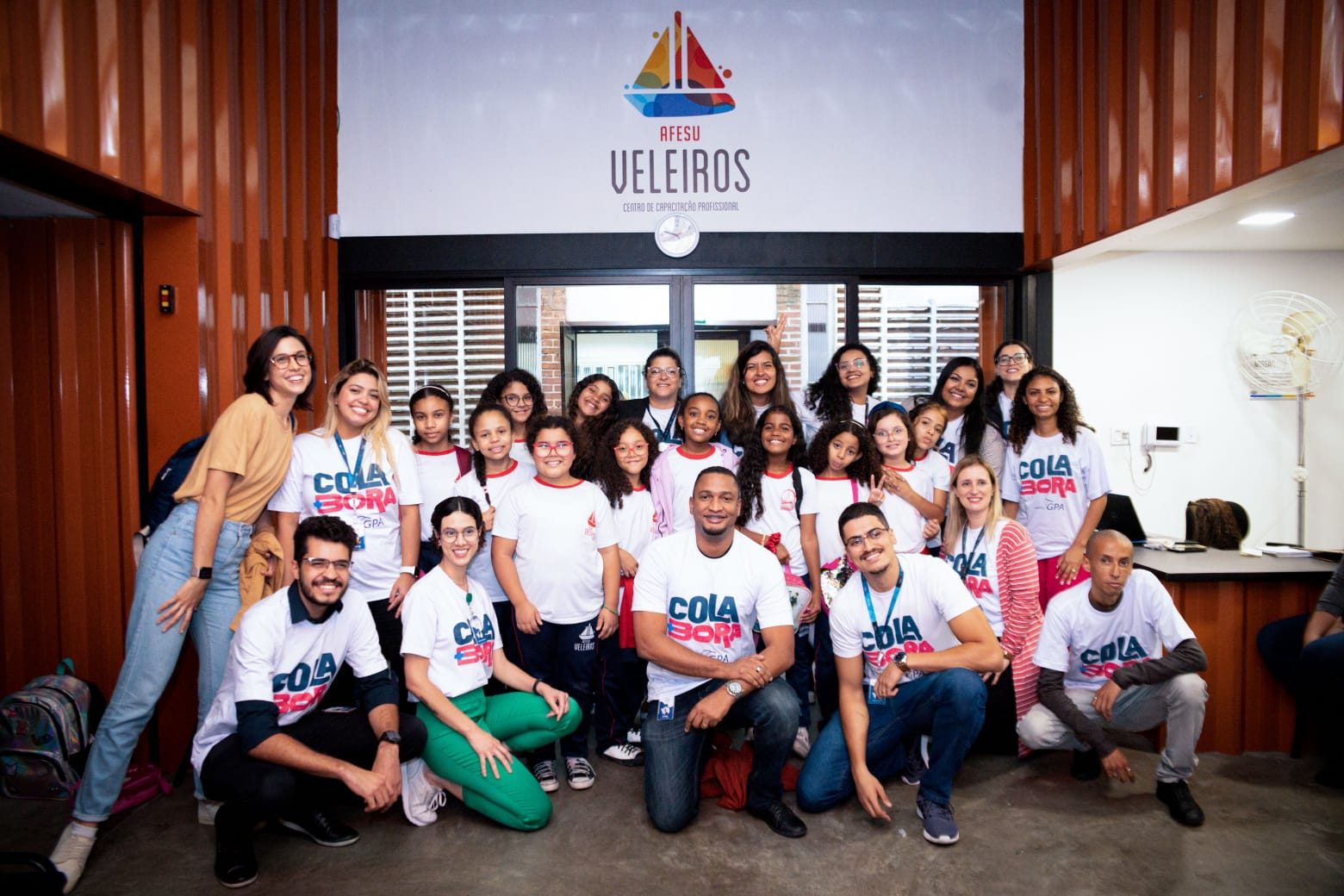Equipe e jovens de um centro de capacitação profissional posam juntos com camisetas da campanha Cola Bora, numa das organizações apoiadas pelo Arredondar